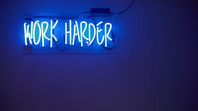 Neon lights spelling the words WORK HARDER