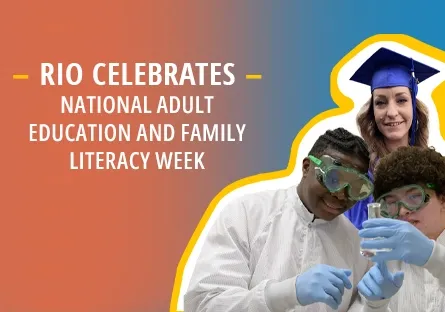 A promotional graphic for National Adult Education and Family Literacy Week. On the right, two students in lab coats and safety goggles examine a test tube, while a graduate in a blue cap and gown smiles in the background. On the left, text reads: Rio Celebrates National Adult Education and Family Literacy Week. The background features a gradient of orange to blue with a bold yellow outline around the students.