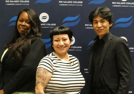 Shaniqua Hopkins, Monse Rodriguez, and Alex Prince stand side by side smiling in front of a Rio Salado College step-and-repeat backdrop at an event.