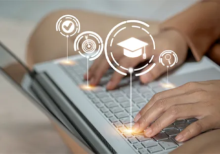Hands typing on a laptop keyboard with digital education icons, including a graduation cap, target, checkmark, and magnifying glass, displayed above the screen.